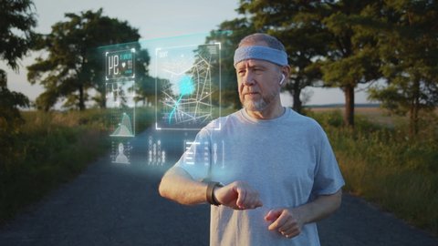Old male sportsman running using latest innovative technology smart watch with augmented reality hologram, checking life system status. Future sport and healthcare concep, immersive digital technology