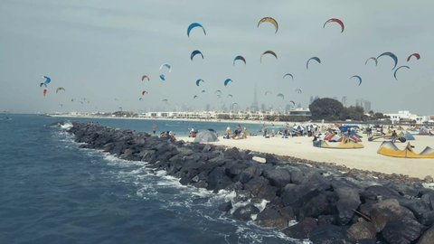 April 16th 2021, Dubai UAE, An Aerial video of Kite Surfers with their colorful Kites flying over the blue sea, with the iconic Dubai Skyline in the background
