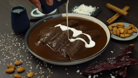 Delicious and traditional mexican dish, enchiladas of mole with cream, cheese and onion rings Stockvideó