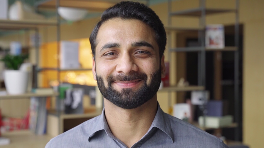 Portrait of young happy indian business man executive looking at camera. Eastern male professional teacher, smiling ethnic bearded entrepreneur or manager posing in office, close up face headshot. | Shutterstock HD Video #1071028858
