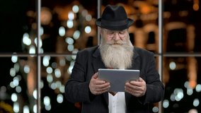 Senior businessman playing game on digital tablet.