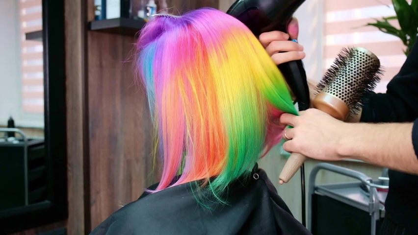 The hairdresser dyes the hair of a blonde woman in different bright colors Royalty-Free Stock Footage #1071032050