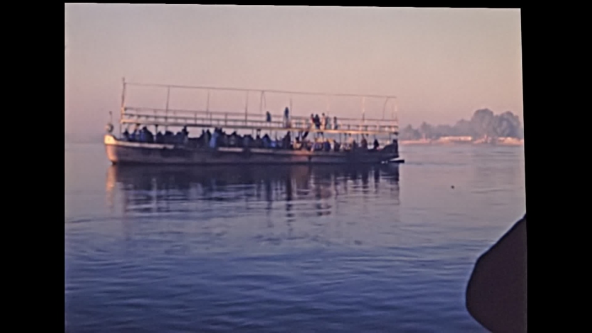 Touristic tour in Luxor city by boat on Nile river. Historical archival of Egypt in 1980s with tourists. Historical archival of Egypt in 1987.