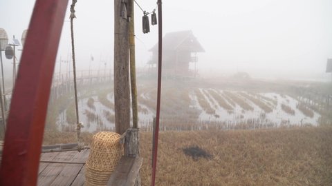 walkway made of bamboo weaves together in a long way with swings in the misty morning.