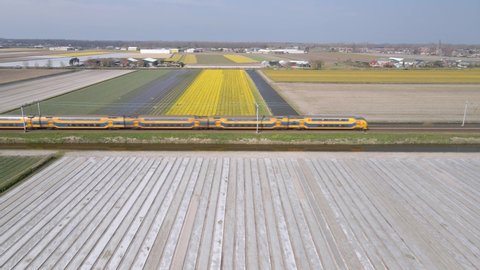 Train track passenger train aerial view of public transport infrastructure in a typical dutch landscape.
