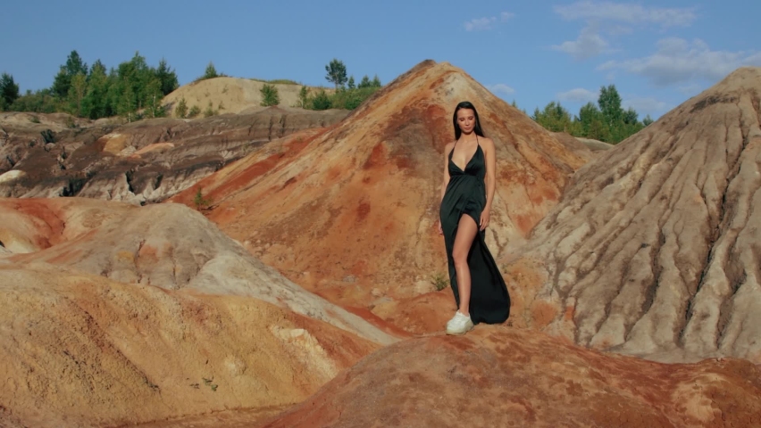 Beautiful woman posing on other-worldly hilly landscape