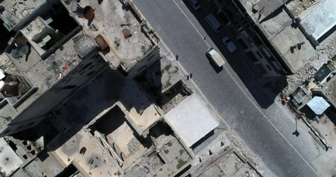Drone flying above a street of Aleppo. We can see truck driving in the street with people around 4k