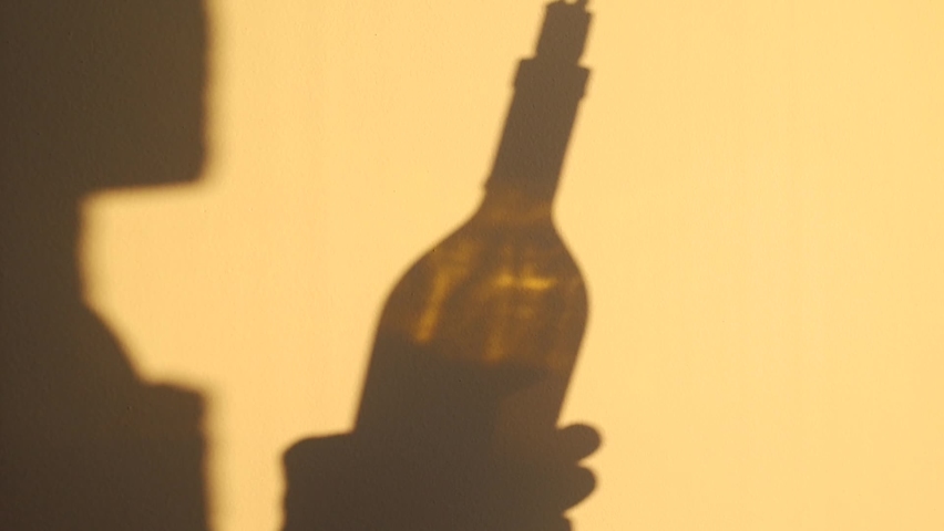 Person Shadow Holding A Wine Glass On Yellow Wall. Shadow Of man Drinking Wine Royalty-Free Stock Footage #1071052540