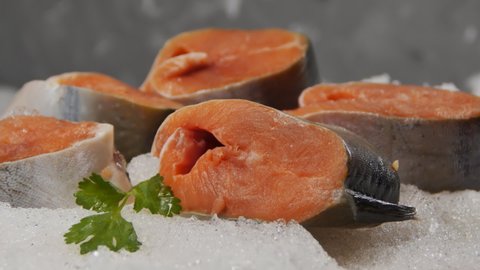 Fresh salmon steaks in the snow rotate slowly. Close-up of red meat fish. Cyclic rotation. Seafood is a source of minerals and iodine.