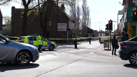SALFORD, MANCHESTER, UNITED KINGDOM - APRIL, 12, 2021: Police cordoned off main road in Eccles, Liverpool Road due to the crime incident, fatal stabbing inside of property above shop.