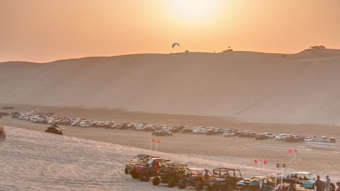Buggies in sand desert at the sunset timelapse. People and jeep cars on weekend. Qatar