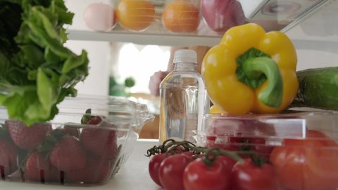 View inside the refrigerator, hand takes bottle from the refrigerator Version 2