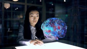 Asian woman Scientist work on 3D Simulated holographic Neural Brain Interface. Engineer using Augmented Holographic Technology. Artificial Intelligence Concept - Powered by Shutterstock - Get 15% off with code: PIKWIZARD15