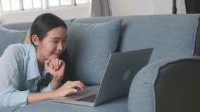 Female Lying On A Sofa And Using Laptop In Living Room, Video In 4K
