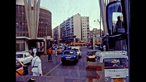 Alexandria, EGYPT, AFRICA - circa 1981: tourists on tour by bus on the street of the Alexandria. Vintage cars in traffic and Ibn Khaldun mosque. Historical archival of Egypt in the 1980s.