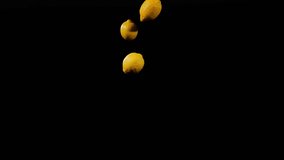 Close up at the group of three lemons fly up and spinning on a black background in slow motion shot, vivid fruit display, flying yellow lemons - Powered by Shutterstock - Get 15% off with code: PIKWIZARD15
