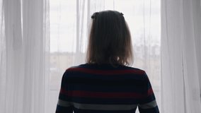 Elderly woman with medical face mask looking through the window. Vulnerable people in quarantine during covid outbreak. High quality 4k footage - Powered by Shutterstock - Get 15% off with code: PIKWIZARD15
