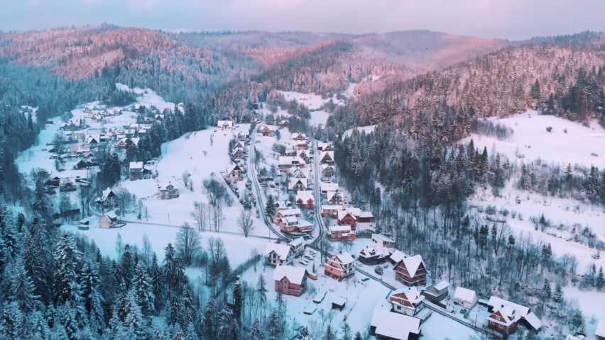 Zakopane, Poland. Arial view of a little town with small houses in a mountain landscape. Street, Houses, and trees, covered in snow with blue sky in the background.  Royalty-Free Stock Footage #1071092695