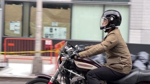 NYC, USA - APR 20, 2021: man in helmet riding Harley Davidson motorcycle in Manhattan New York City.