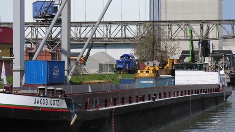 Load and offload of mooring freight ships at harbour in Basel. CH Switzerland, 21th April 2021