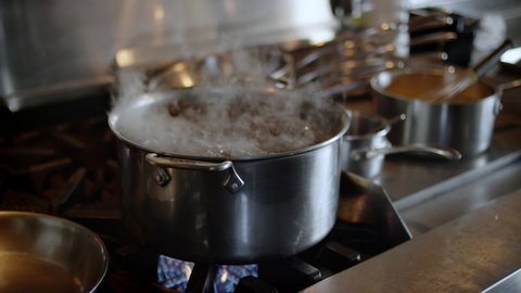 Slow motion shot of water boiling in a pot in a restaurant kitchen