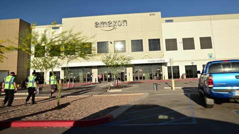 April 21, 2021 - Tucson Arizona. New Amazon fulfillment warehouse building. Drive by in the parking lot. People in yellow vests enter building. 
