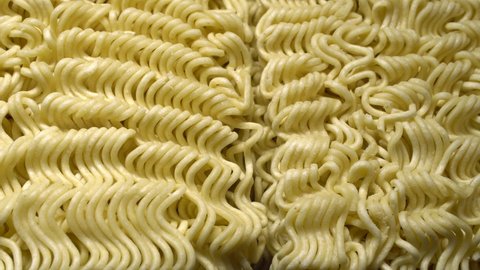 Instant noodles. Close up of raw dried noodles. Uncooked noodles texture. Precooked dehydrate noodle blocks. Asian food. Food background.