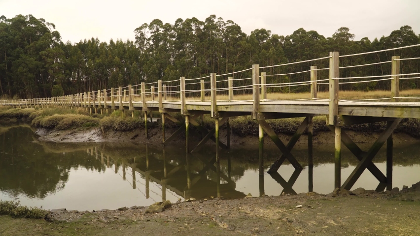4K close up on a wooden food path over a low tide pond in the Ria de Aveiro on the estuary of the river Vouga. Royalty-Free Stock Footage #1071108856