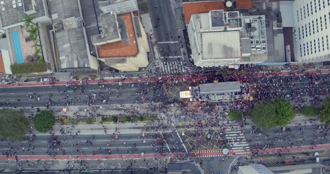 Aerial birds eye shot of people walking during gay parade, Sao Paulo. Dolly left