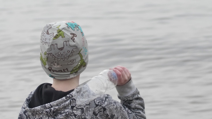 The boy threw an empty bottle into the sea