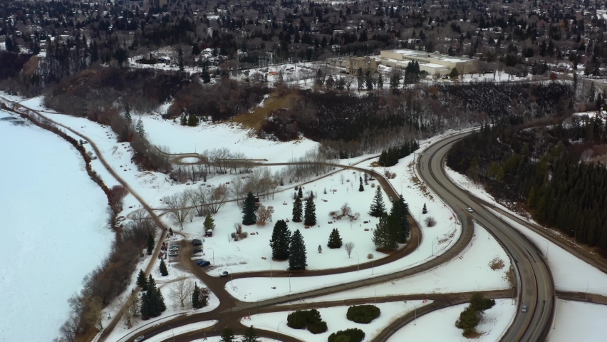 winter aerial semi birds eye view fly over Victoria Park headed towards Governement House Park by Groat Rd NW river valley road next to the monument Ksan Totem Pole and the Korean Pavillion museum 1-2
