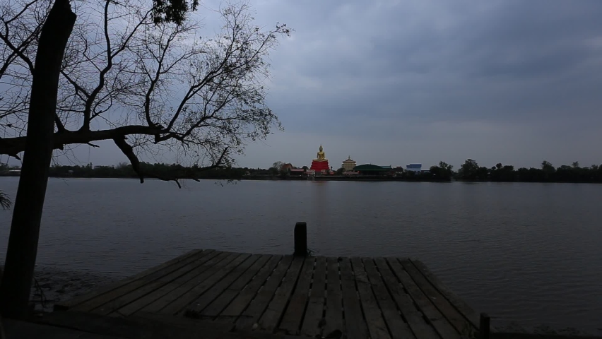 Video background along the river, overlooking a large Buddha statue (Wat Prasasopon), a religious tourist attraction in Chachoengsao Province of Thailand.
