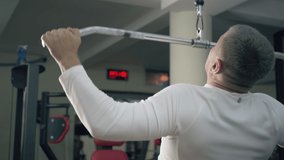 Gym workout. Bodybuilder performs lat pulldown at the gym. Strong male doing exercise for muscles of the back. - Powered by Shutterstock - Get 15% off with code: PIKWIZARD15