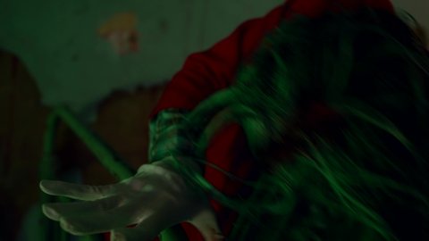 clown cosplay, mad person with green hair and red jacket is swaying in dark room