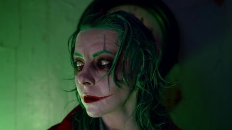 actress with green hair and makeup of clown, portrait of cosplay on movie and comics character