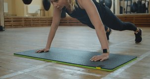Slimming caucasian woman doing gym routine. Fit model does push ups as a part of training session - healthy lifestyle concept.