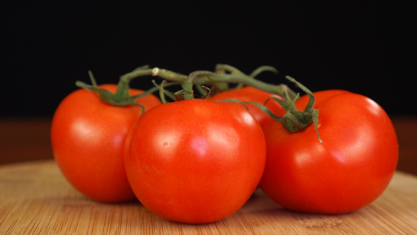Man placing decorative toothpick with flag of Peru into bunch of tomatoes.