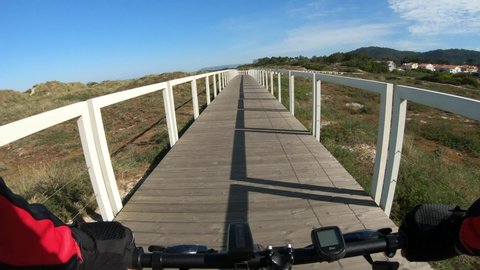 Esposende, Portugal, April 18, 2021:  POV SHOT of biker riding bike. First Person View of a man cycling in the Ecovia Litoral Norte (North Coast Ecoway), walking or cycling path.