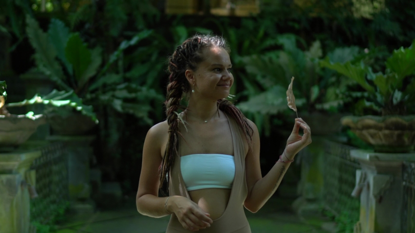 Happy Caucasian woman in active sportswear exploring Indonesia during yoga tour searching place for training practice, smiling female enjoying summer vacations during solo travelling