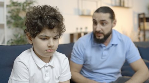 Strict father scolding son, criticizing sad little boy for mistake, parenting