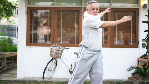 Asian senior man exercise at home. Healthy elderly male do stretching workout tai chi in the garden. Retirement person enjoy outdoor leisure activity at home. Older health care and wellbeing concept
