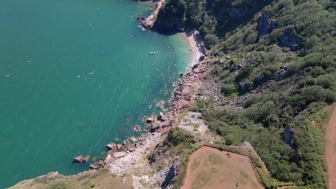 Aerial top down shot of long Quarry View point and steep cliff slope with clear blue water in the valley. Torquay,England.