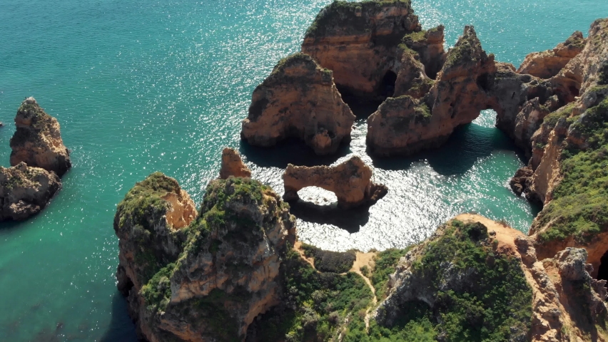 Stone Arch 'Catedral' in Algarve Coastline in Lagos Portugal - Aerial Orbit slow tilt-up shot | Shutterstock HD Video #1071150415