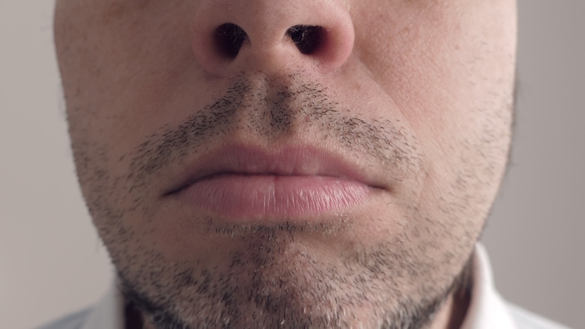 Sick man spray medicine into his mouth. Face macro shot