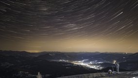 Night starry sky over village in Carpathians, view from above, 8k UHD video timelapse