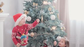 authentic happy Joy children with sparklers by decorated Christmas tree playing have fun together. Preschool toddler baby celebrate New Year festive atmosphere at home. Winter, holiday, Family concept