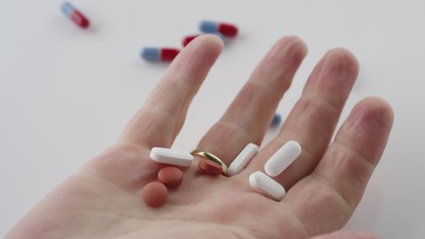Close up shot of pills flying out of a hand after they passed out