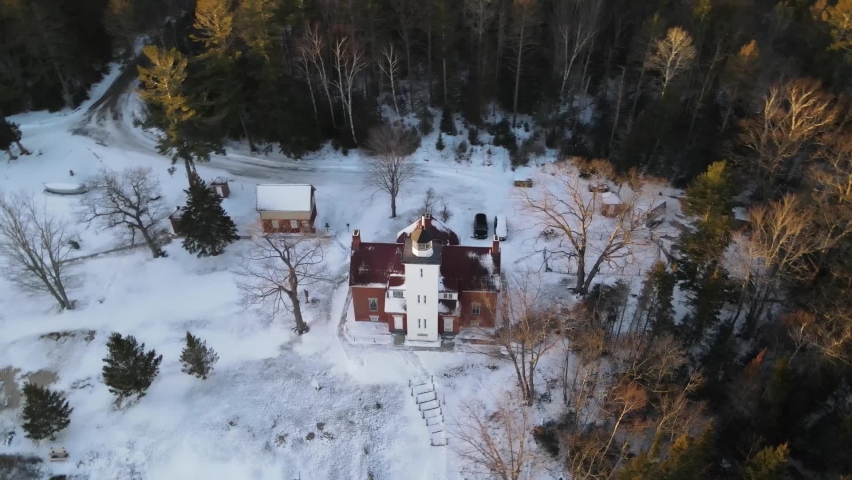 4k drone video of 40 Mile Point Lighthouse in Presque Isle County in Michigan during the winter.
