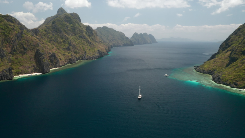 Aerial flying over a sailyacht by Matinloc Island, El Nido, Palawan, Pilippines. Royalty-Free Stock Footage #1071179398