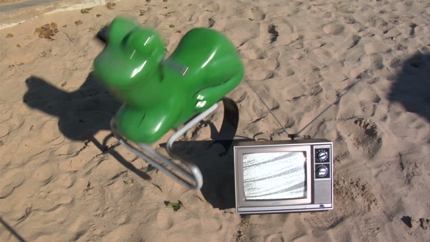 retro tv next to a bouncy frog in the park.  
